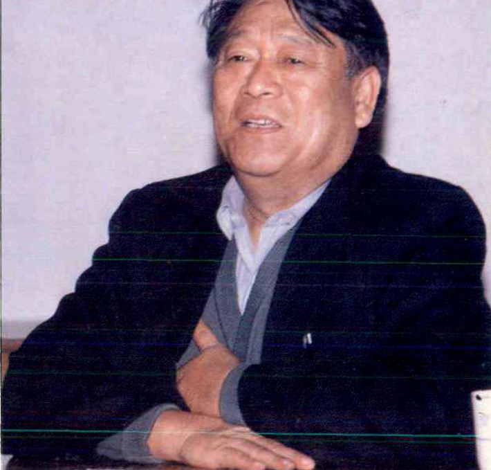 一名中年男子坐在室内的半身肖像照片