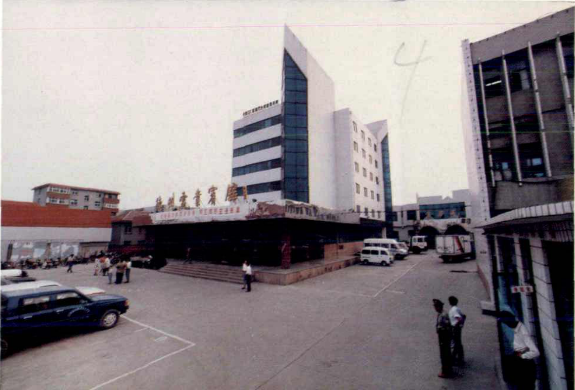 电力宾馆建筑外观照片，门前广场停放多辆汽车并有行人。