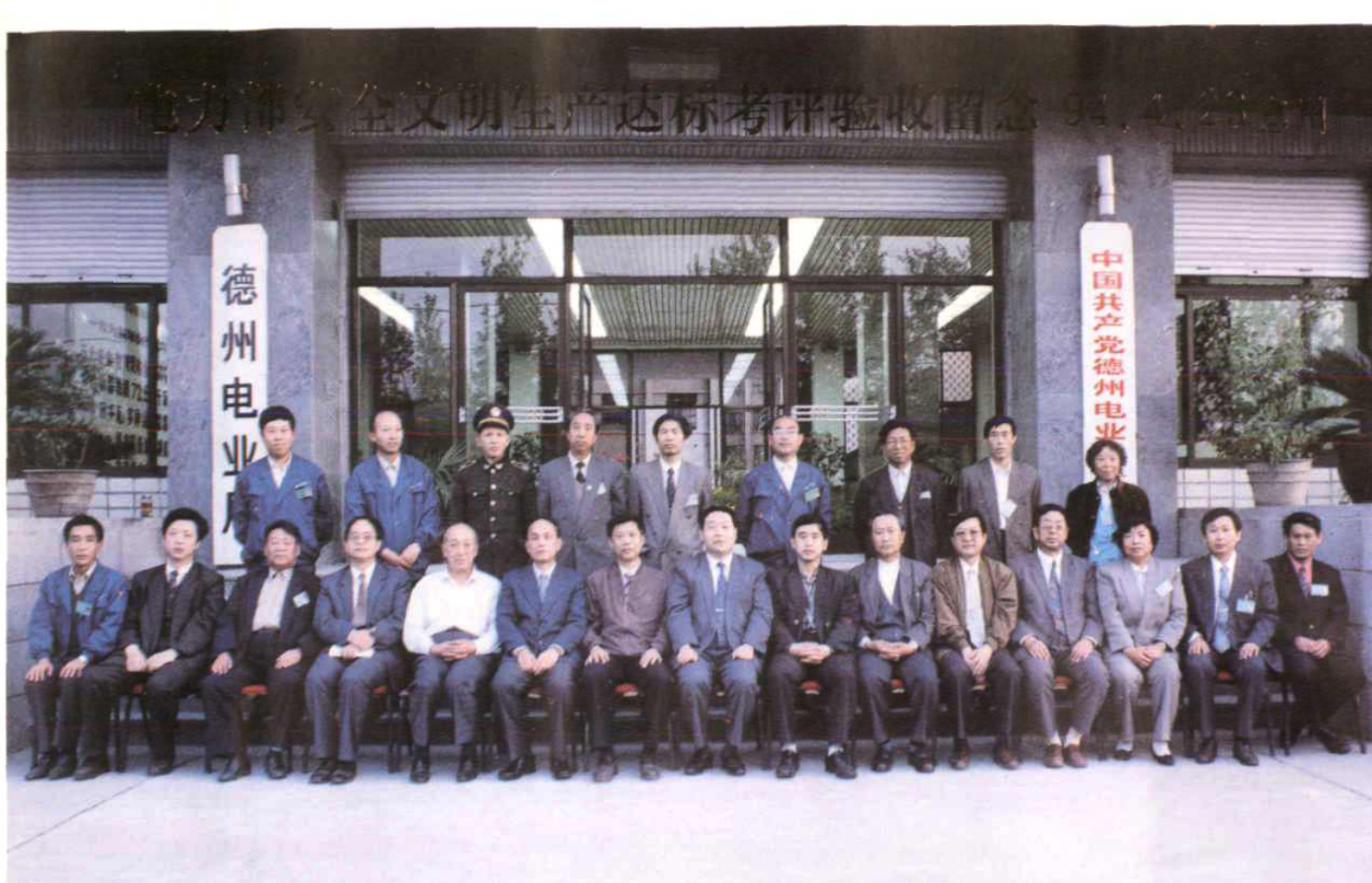 多人合影照片，背景为建筑物门前