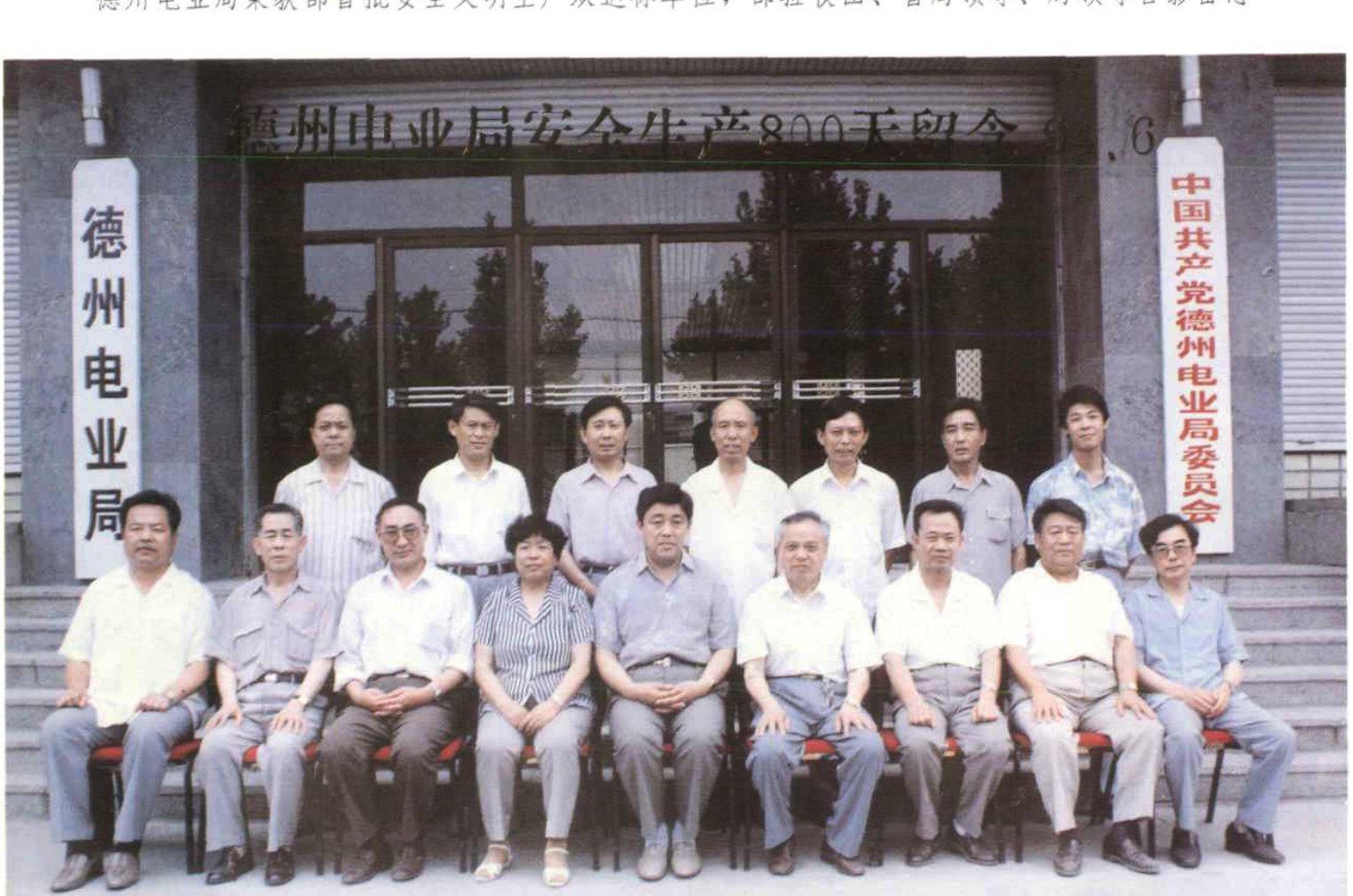 多人合影照片，背景为建筑物门前