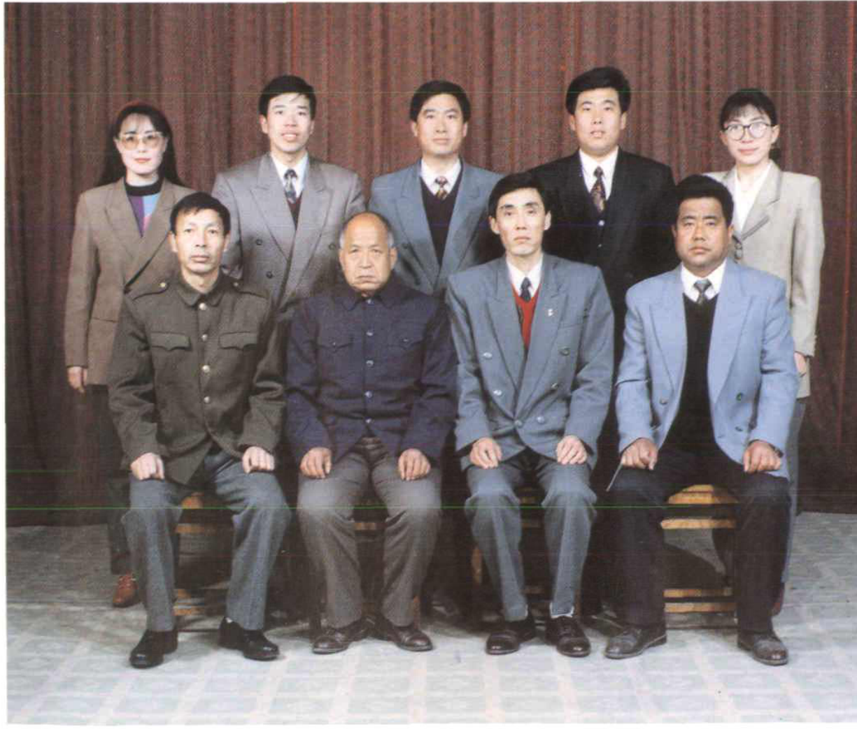 彩色合影照片，前排坐四人，后排站五人