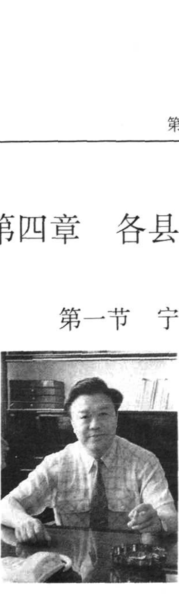 一张人物黑白照片，男子坐在办公桌前