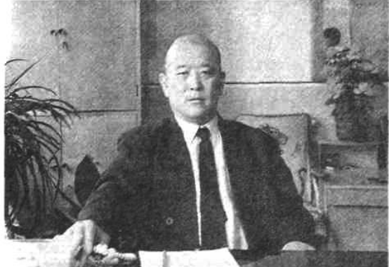 一名男子坐在办公桌前的人物半身照片