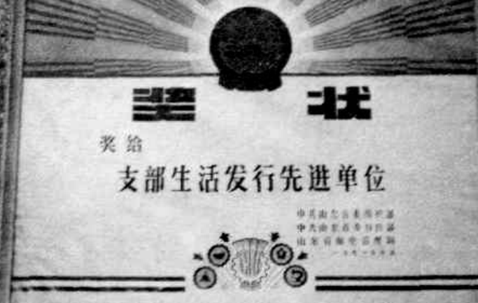 一块奖牌，上面有文字和图案，奖牌下方是两个圆形徽章。