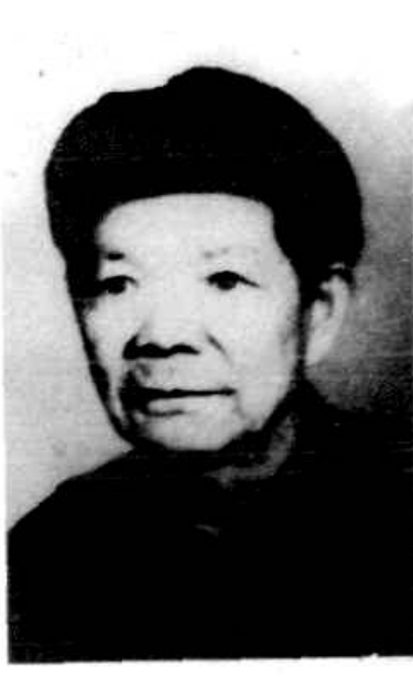 一位年长女性的正面半身照，她穿着深色衣服，面带微笑。