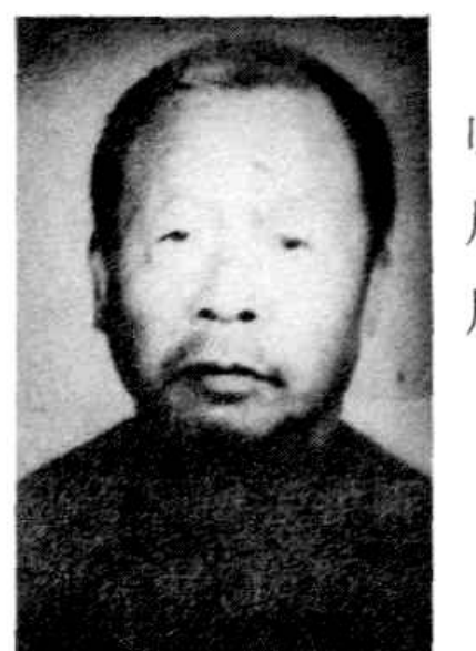 一位身着深色上衣的老年男性，面部清晰，表情严肃。