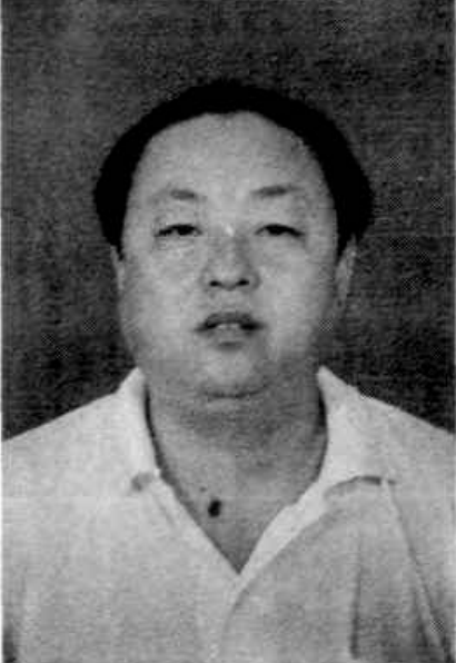 一名中年男性，穿着浅色衬衫，正面入镜。
