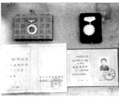 桌面上摆放着几份证书、奖章和证件。