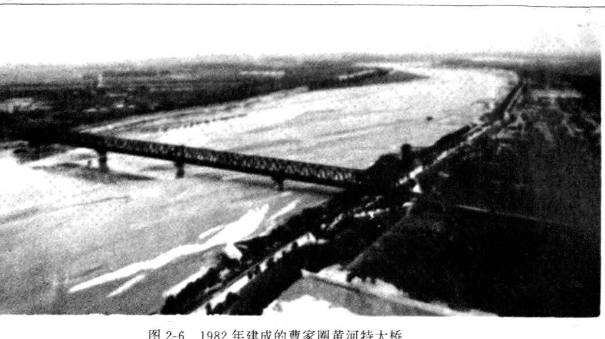 黑白照片，展示了横跨黄河的大桥远景及河道堤防景观