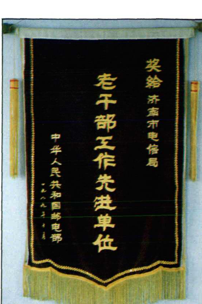 一面深蓝底黄字的锦旗，上书“老干部工作先进单位”及落款。