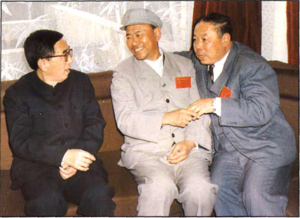 三位男子坐在沙发上交谈，背景有竹叶图案的窗帘或墙面