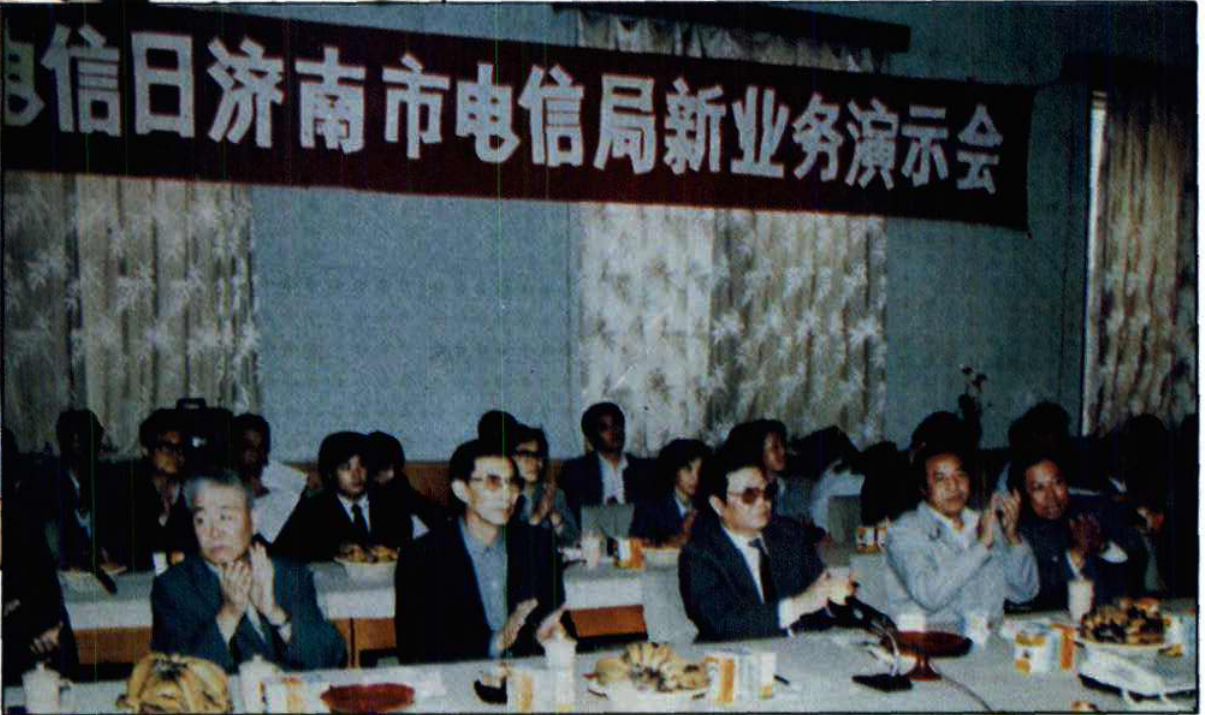 电信日济南市电信局新业务演示会会场内人员鼓掌的照片