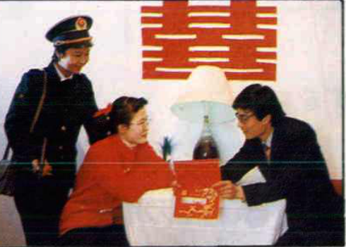 两名工作人员向民众赠送物品的场景
