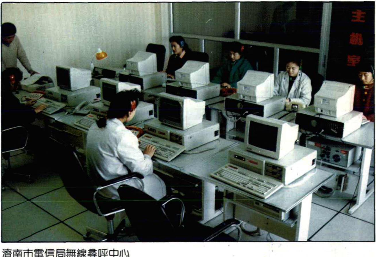 多人正在机房内操作电脑和寻呼设备的场景