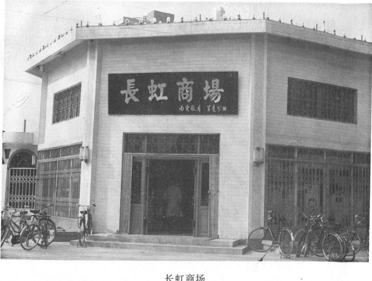带有“长虹商场”招牌的建筑外观，门前停放着多辆自行车