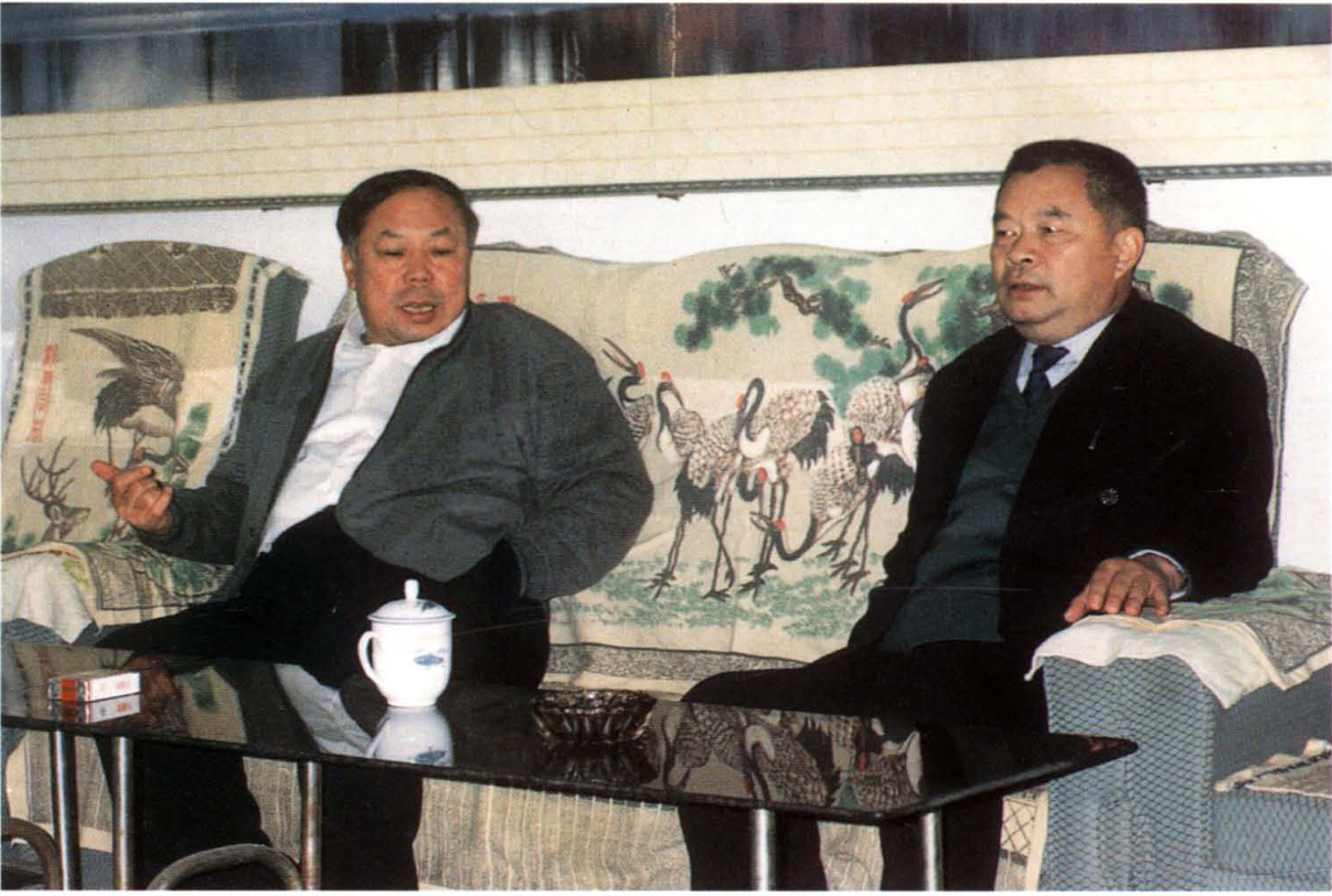 两位男子坐在沙发上交谈的照片