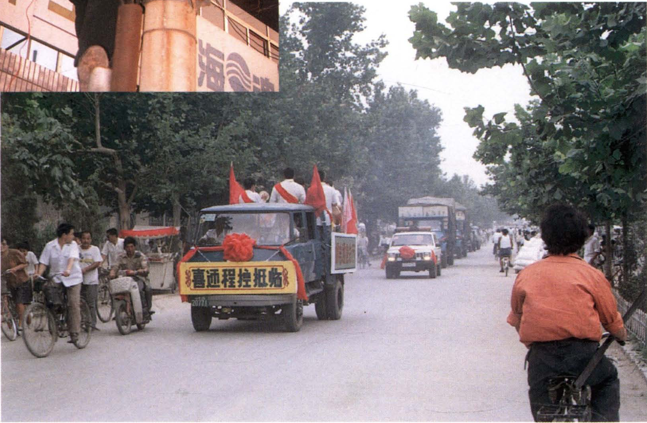 挂有横幅的卡车车队行驶在街道上，周围有骑自行车的行人和道路树木