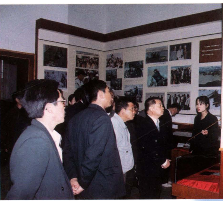 多人正在室内参观纪念馆展板。