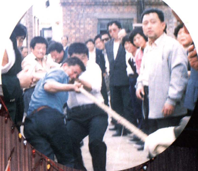 圆形画面内人们正在进行拔河比赛的场景