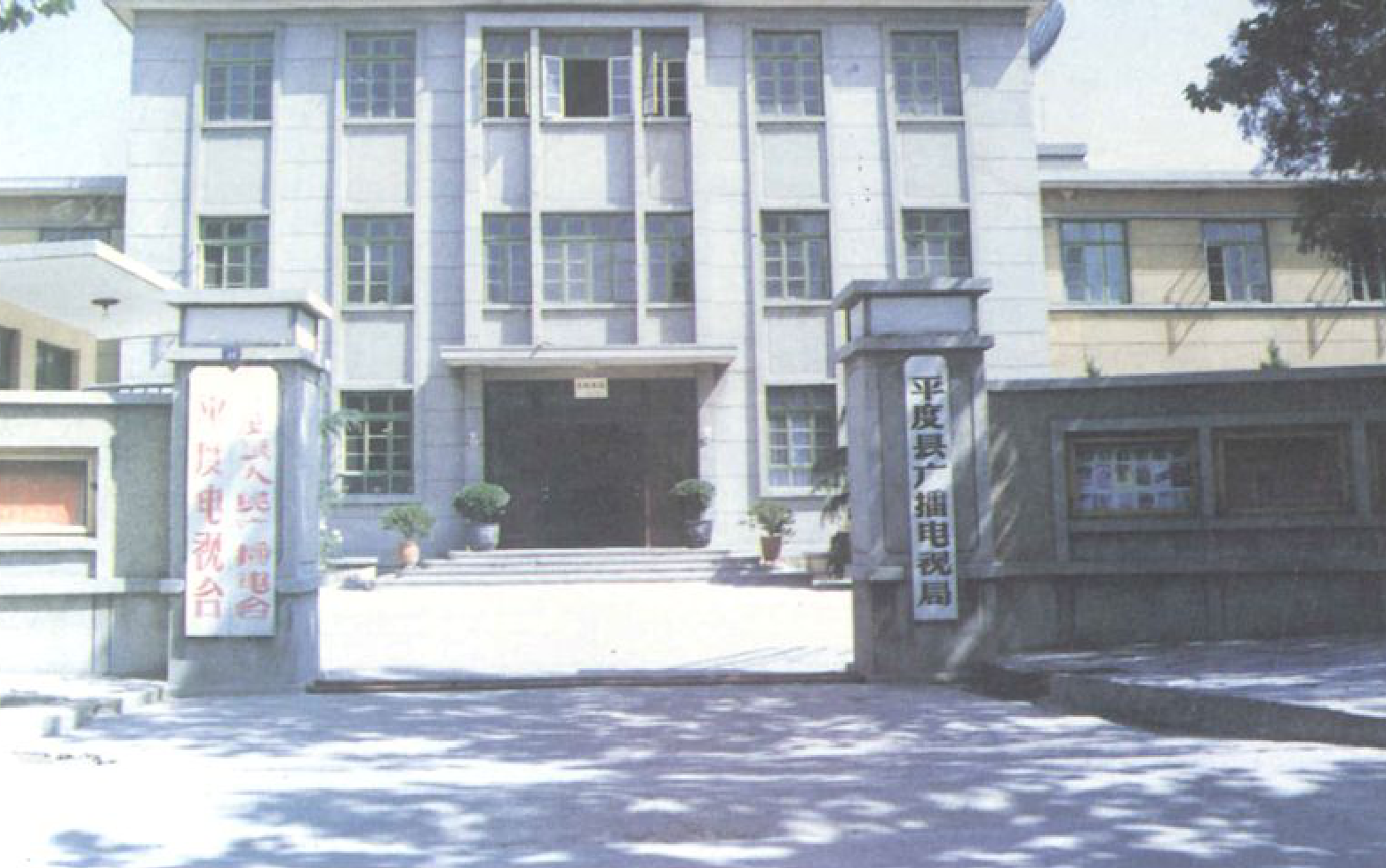 一座多层灰色建筑，前面有门柱和牌匾。