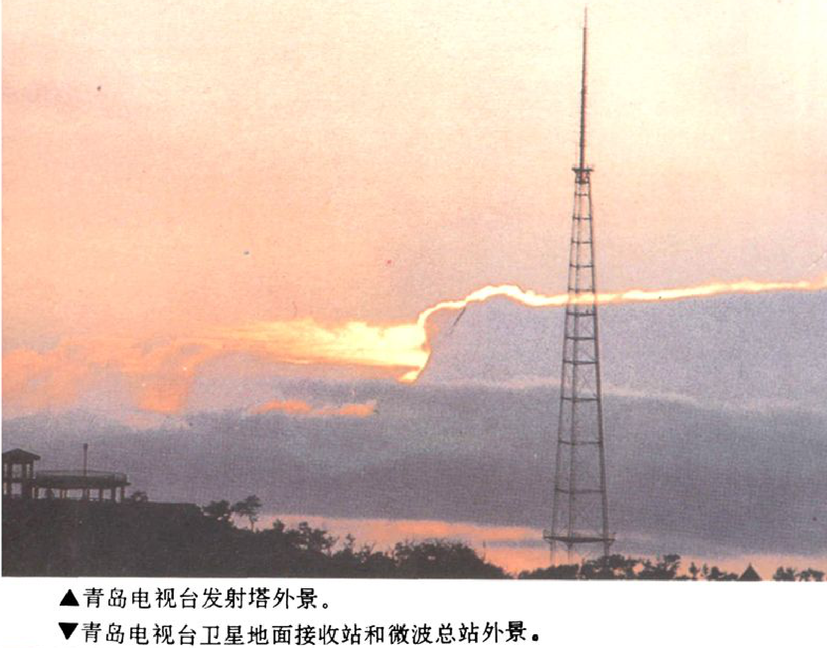 夕阳下，一座高耸的铁塔形发射塔。