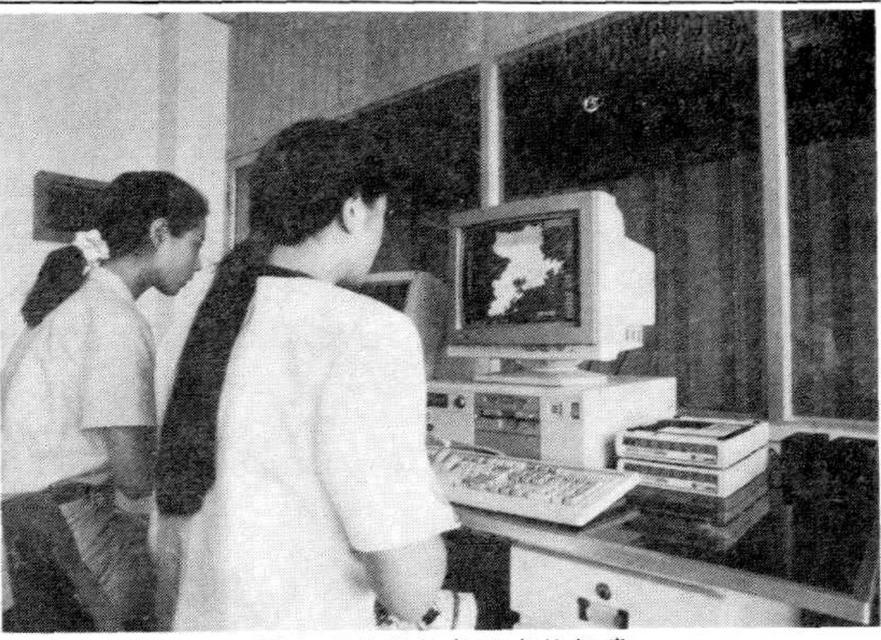 两名工作人员在80年代的程控长途交换机房内工作
