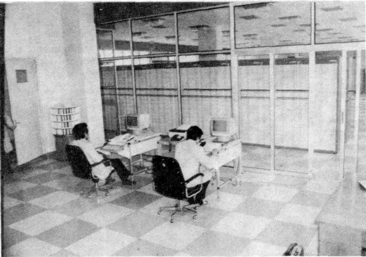 黑白照片显示机房内两人坐在电脑桌前工作