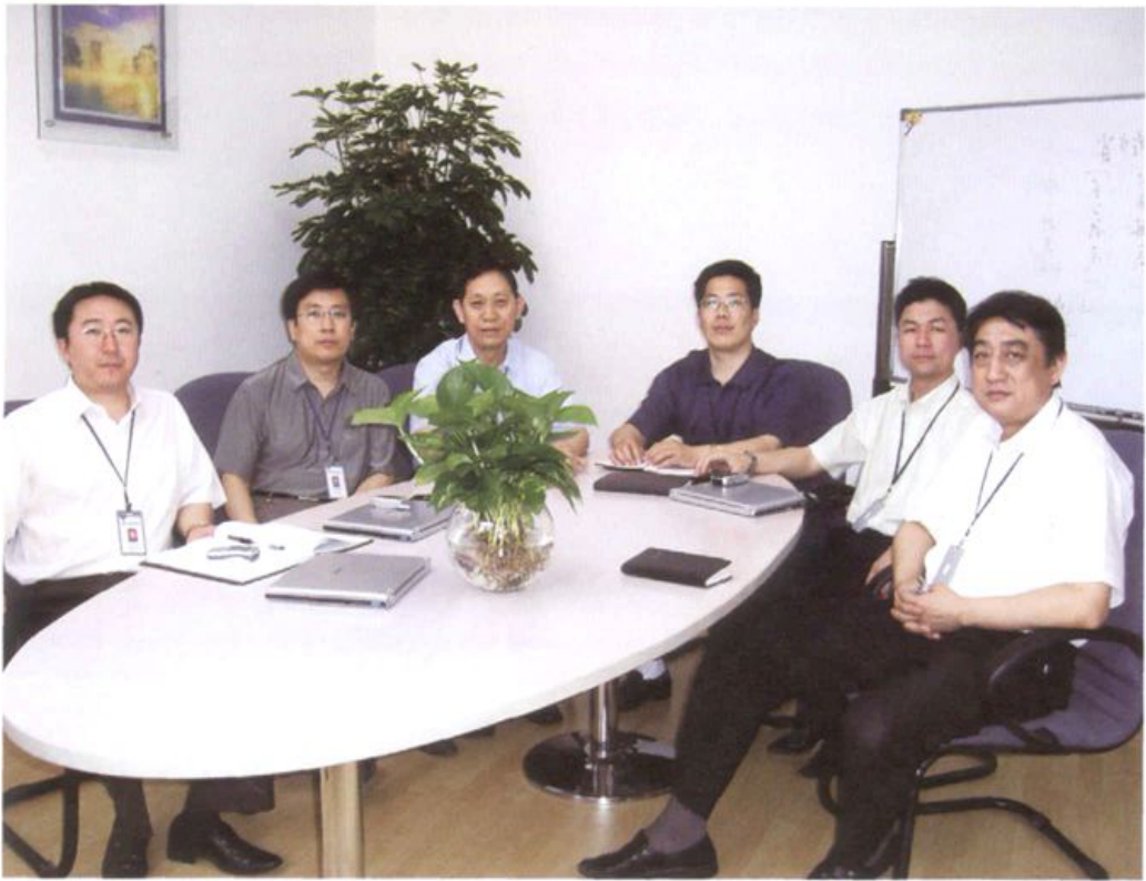 七位男性围坐在会议桌前开会的合影