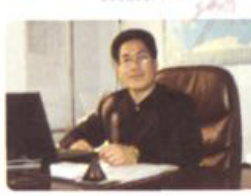 一名男子坐在办公桌前使用电脑办公
