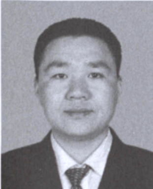 黑白人物证件照，一名男性身穿西装衬衫与领带。