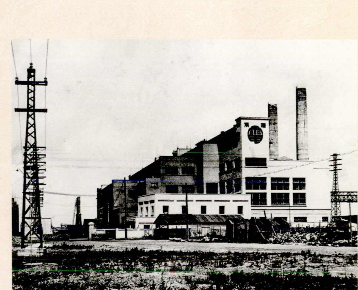 1934年建设的青岛四方发电所全景，包括厂房、高耸的烟囱和电线塔。