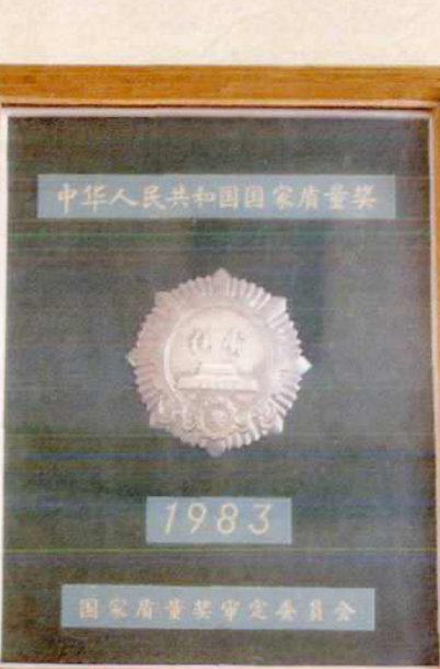 一个木框装裱的证书，中间是一个带有“国家荣誉”字样的徽章，下方是年份和委员会名称。