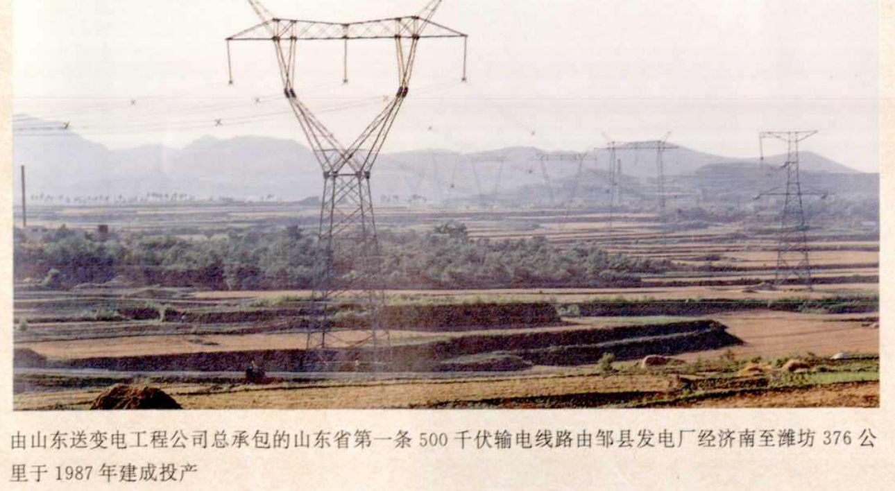 高耸的铁塔架设在田野上，远处有连绵的山峦。