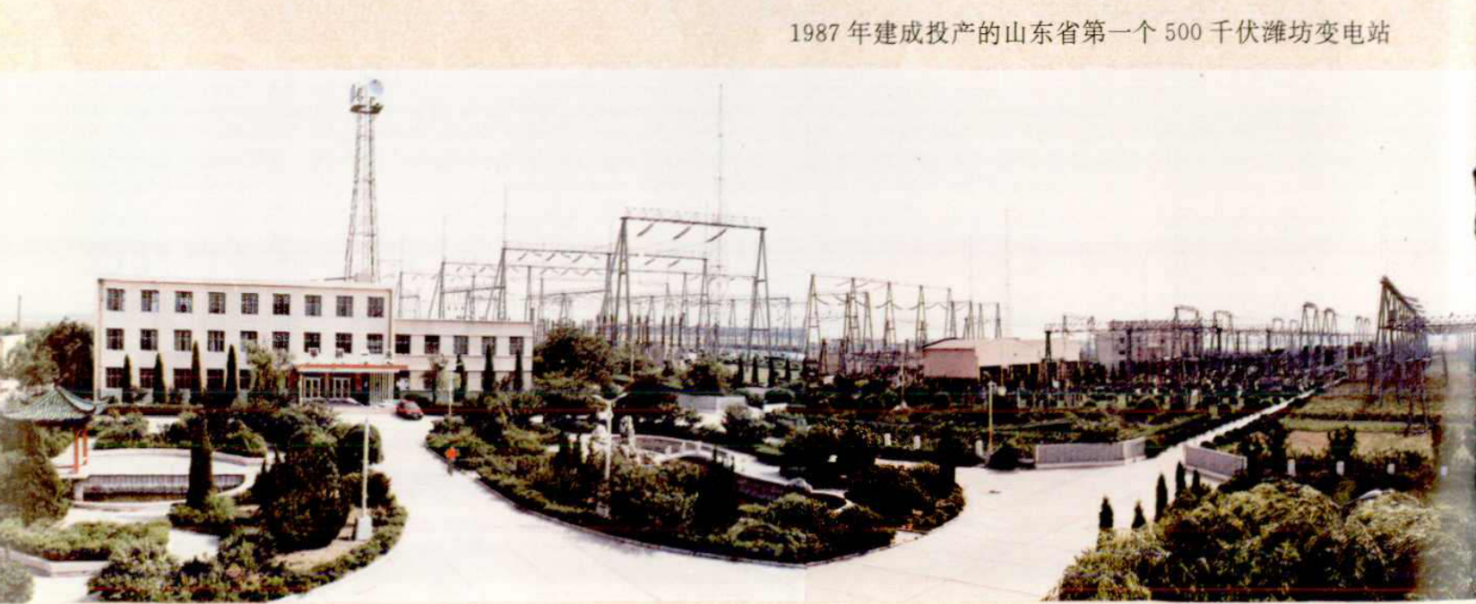 一栋白色建筑和旁边的变电站设备，有整齐的绿化带和道路。
