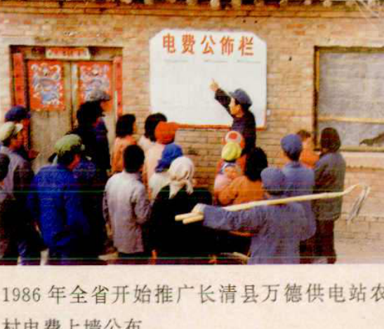 一群人在一间房屋前，有人在黑板上写字，黑板上写着“电费公佈栏”。