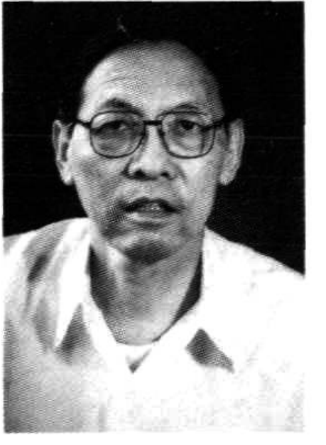 一位戴眼镜的年长男性，身穿深色西装和浅色衬衫。