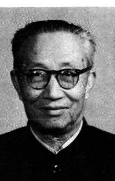 一位年长的男性，戴着眼镜，穿着深色夹克，面带微笑，面向镜头。