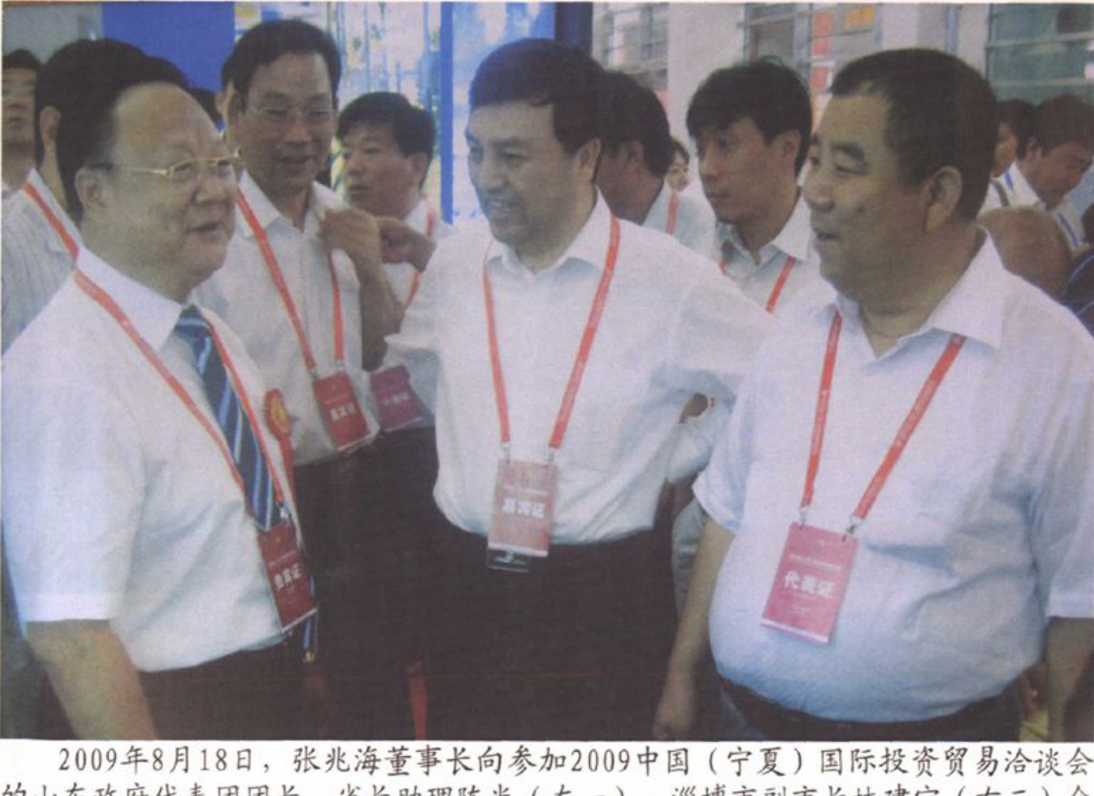 几位佩戴证件的男子在一处展会或活动现场交谈。