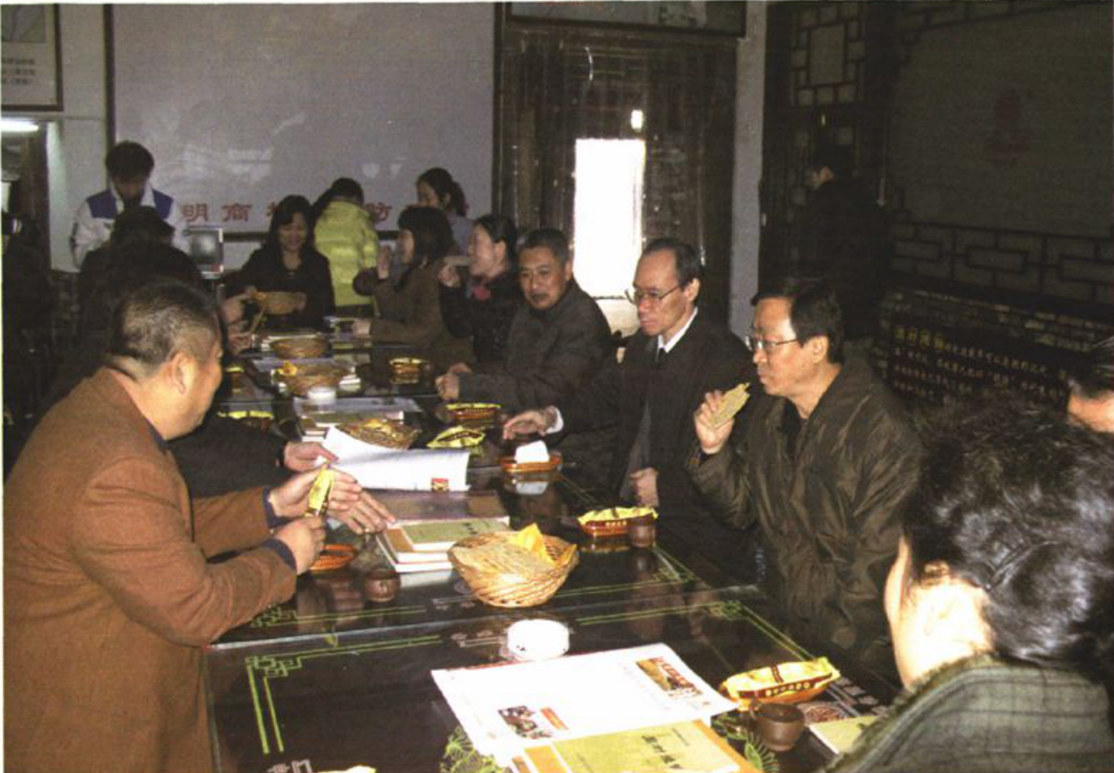 多人围坐在长桌旁进行考察调研的室内照片