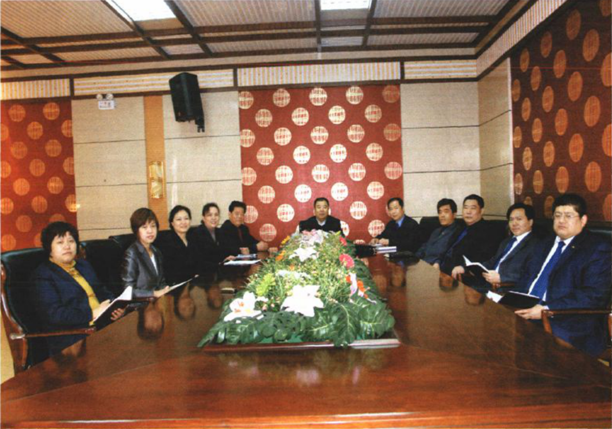 多名男女领导围坐在长条会议桌旁开会的场景