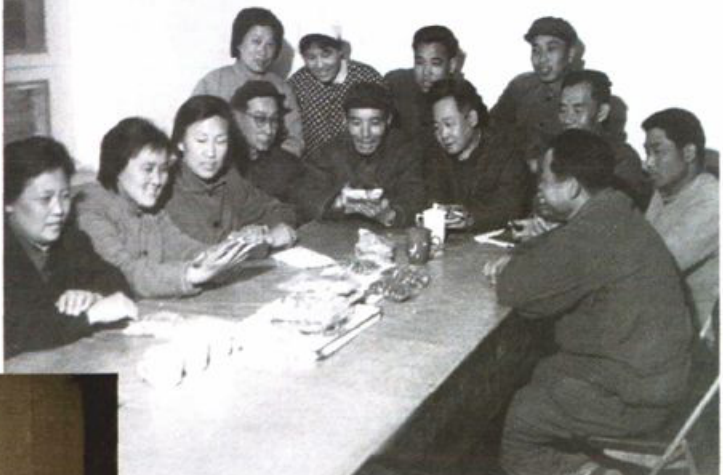 黑白会议场景照片，多名男女围坐在长桌旁。