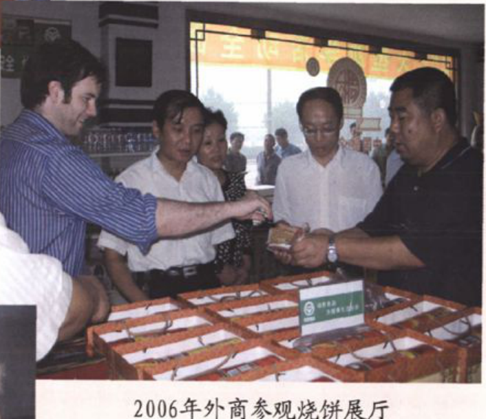 外商参观烧饼展厅并观看展品的照片
