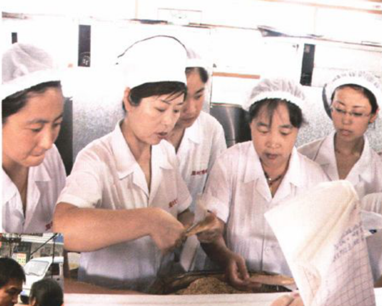 多名身穿工作服和厨师帽的人员在进行技术竞赛时检查产品质量的场景