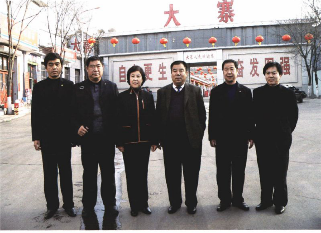 六名男性和一名女性在建筑前合影
