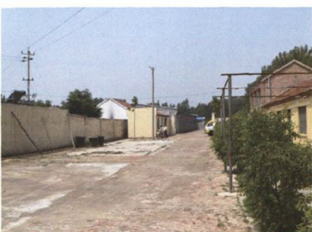 一条水泥路面街道与两侧房屋建筑的照片