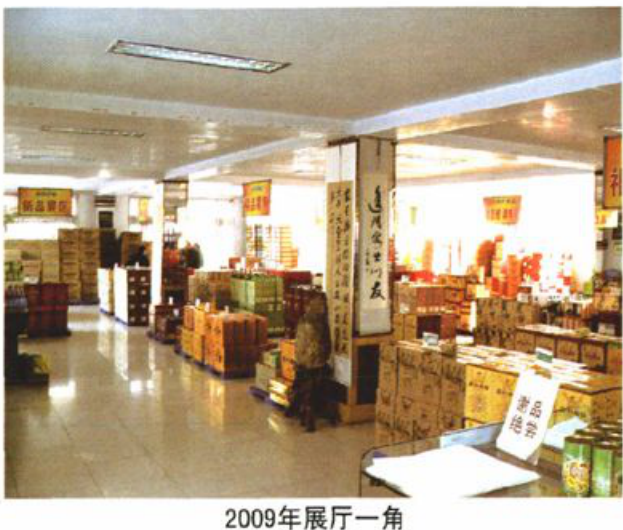 室内展厅照片，货架上摆满商品，地面有柜台和展示物