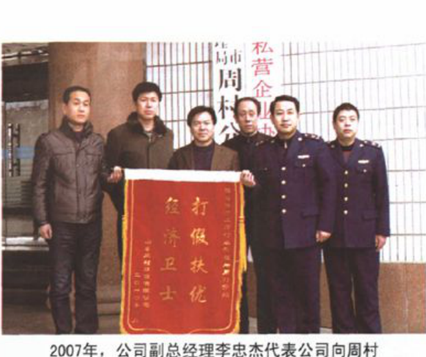 几名男子手持一面印有金色大字的红底锦旗合影