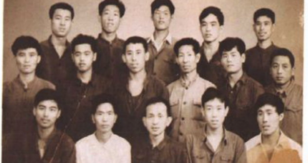 黑白合影照片，多名男性工人站在室内