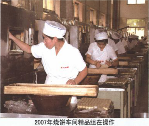 两名佩戴帽子的工人在烧饼车间操作
