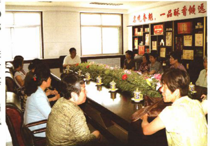 多人参加的室内座谈会场景，有人在发言或交流。